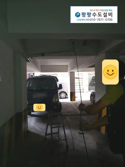 지하 주차장 천장 배관에 호스를 넣는 작업자